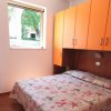 Camera da letto con armadi arancioni sopra il letto.