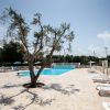 Una piscina con lettini e ombrelloni.