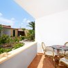 Veranda con tavolo, sedie e giardino fiorito.