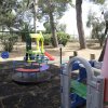Parco giochi all'aperto con giostre colorate.