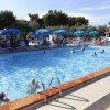 Piscina con lettini e ombrelloni blu.
