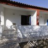 Veranda esterna di una casa con tavolo e sedie.