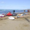 Spiaggia con attrezzatura per kite surf e persone.
