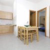 Cucina aperta con tavolo in legno e sedie.