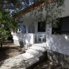 Facciata di casa bianca con alberi e veranda.