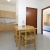 Cucina con tavolo da pranzo e sedie in legno.