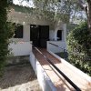 Ingresso di una casa circondata da alberi e cespugli.