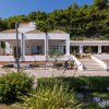Casa bianca con giardino e fiori in primo piano.