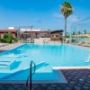 Piscina con lettini e ombrelloni arancioni.