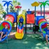 Bambini su scivoli colorati nel parco giochi.