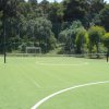 Campo da gioco in erba sintetica, rete e porte.