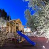 Parco giochi con scivolo blu e piattaforma in legno.