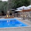 Piscina al tramonto con alberi di ulivo e sdraio.