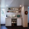 Cucina piccola con mensole e mini-frigo.