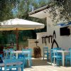 Patio con tavoli, sedie blu e amache.