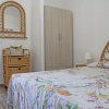 Camera con letto decorato e specchio.