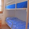 Letto a castello con lenzuola blu.