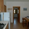 Cucina con tavolo e sedie, frigo, fornelli e decorazioni alle pareti.