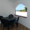 Terrazza con tavolo e sedie nere, vista mare.