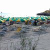 Spiaggia con ombrelloni gialli e verdi e lettini.
