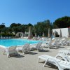 Piscina con lettini e ombrelloni chiusi.