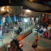 Band suona vicino a una piscina con pubblico seduto.
