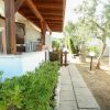 Veranda con giardino e vialetto accanto a un barbecue.
