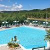 Una piscina all'aperto circondata da lettini e ombrelloni.