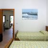 Camera con due letti singoli e quadro marino.
