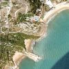 Immagine satellitare di una costa con spiagge e vegetazione.