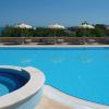 Ampia piscina blu con vista su un paesaggio verde.