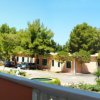 Balcone con sedie, vista giardino e alberi.