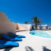 Piscina con lettini blu e palme.