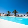 Ampia piscina circondata da palme.