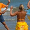 Persone in spiaggia partecipano a una lezione di danza.
