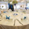 Sala per eventi con tavoli rotondi decorati.