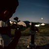 Persona che osserva al telescopio di notte.