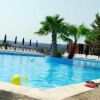 Piscina all'aperto con lettini e palme sul bordo.