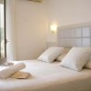 Letto matrimoniale con cuscini bianchi e asciugamani piegati.