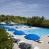 Piscina all'aperto con ombrelloni blu.